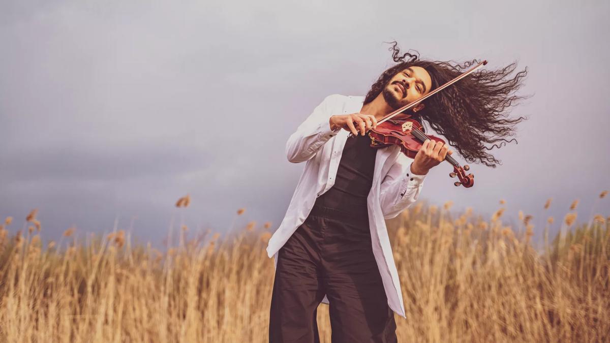 Nemanja Radulović playing violin in a field
