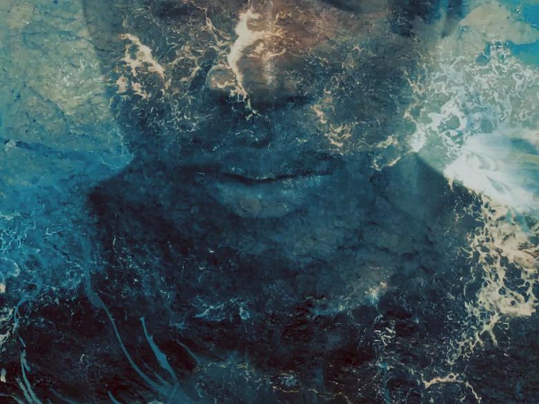 Image of a Black woman's face and shoulders is layered over by a swirling blue ocean. 
