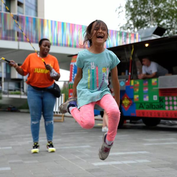 A woman and a young girl playing with a skipping rope 