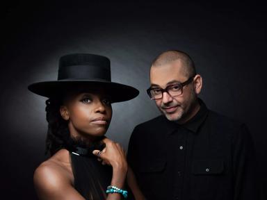 Two members of Morcheeba against a black background wearing  black clothes, one person in a hat.