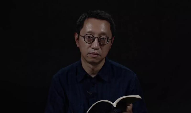 Kit Fan a Hong Kong born man wearing round glasses reads from their TS Eliot Prize shortlisted collection against a black background