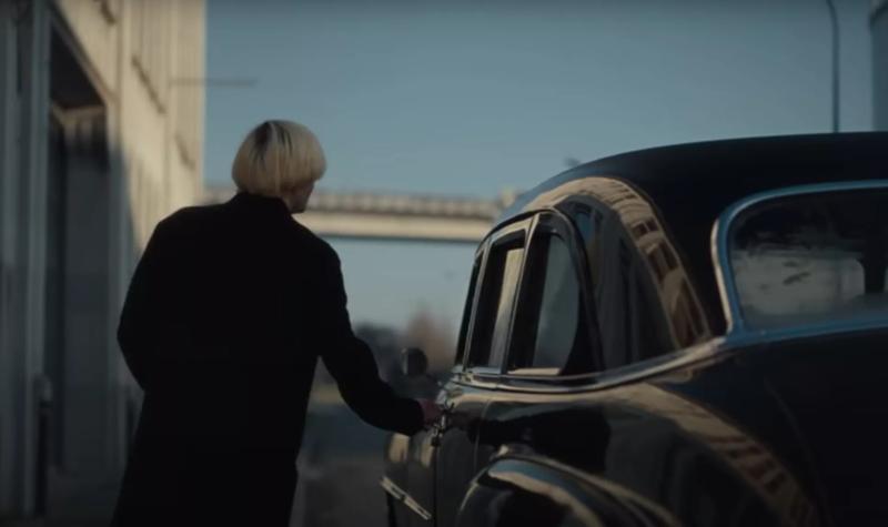 Tim Burgess, seen from behind, goes to open the door to a vintage car