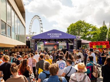 A concert being held at Riverside Terrace outside Royal Festival Hall with an audience in summery colthing