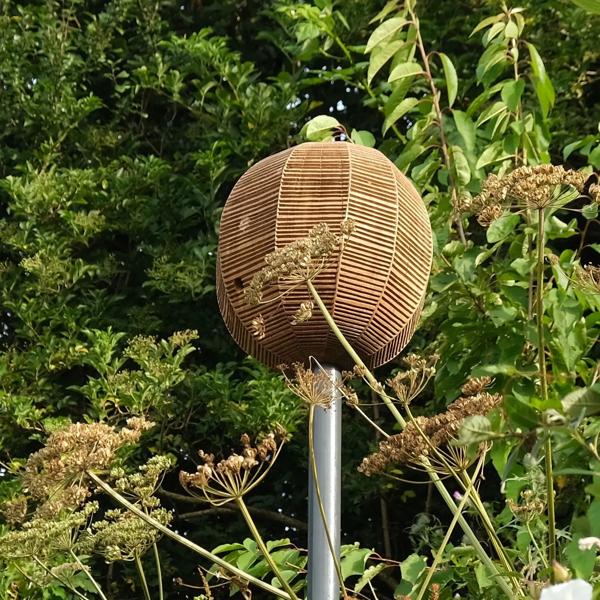 A wooden beehive on a pole in the forest