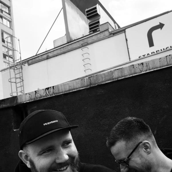 Two men smiling in black and white 