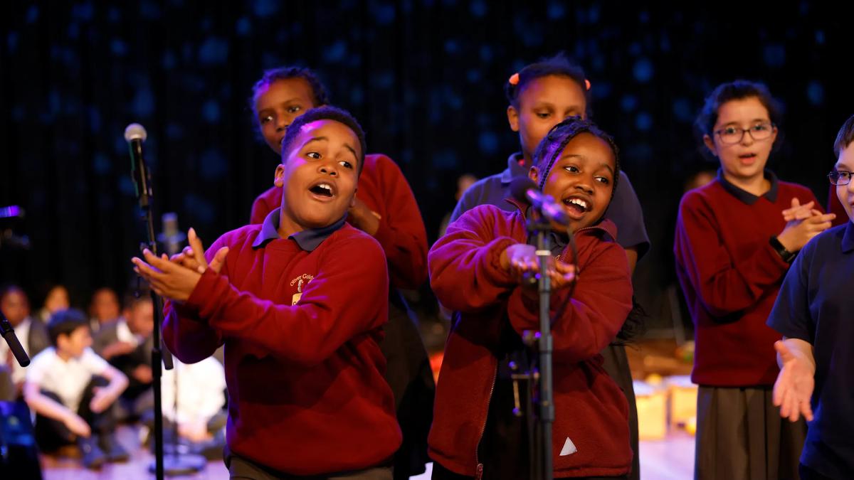 Kids on stage singing and clapping