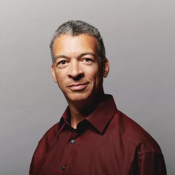 Baritone Roderick Williams looking straight at the camera, in a red collared shirt