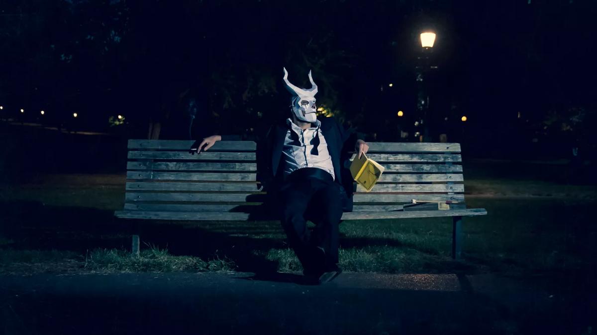 Aurora Orchestra, person in a mask sitting on a bench