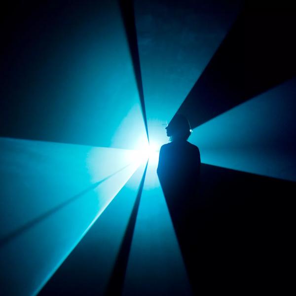 Woman standing in Blue Light Beam by artist, Anthony Mccall at Hayward Gallery