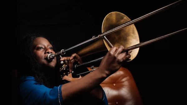 Portrait of a Black woman playing trombone