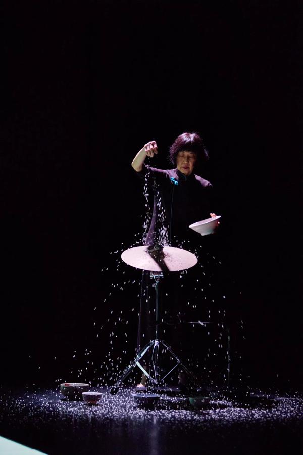 Margaret Leng Tan sprinkling rice on a cymbal and stand