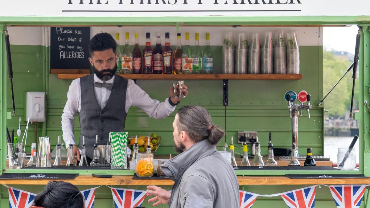 A bartender making a cocktail in a green truck