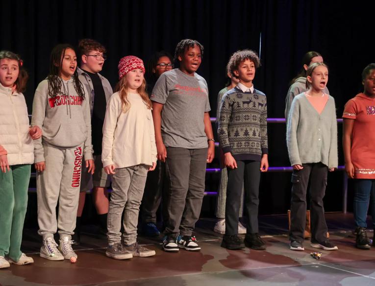  Southbank Centre Youth Voices - a choir for children and young people. This image was captured at a performance in December 2023 and shows a diverse choir of young people aged 10-16 singing enthusiastically on stage.