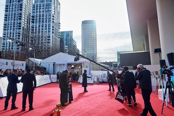 People standing on the red carpet in suits.