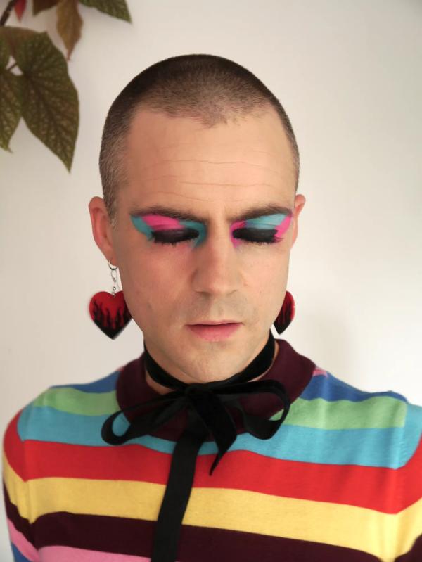 William Wyld with pink and blue eyeshadow and a rainbow t shirt
