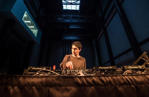 Photo of DJ Mo Probs in front of decks. 