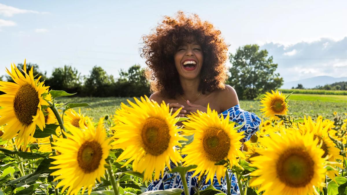 Yilian Cañizares, Cuban-Swiss musician pictured in a bed of sunflowers laughing