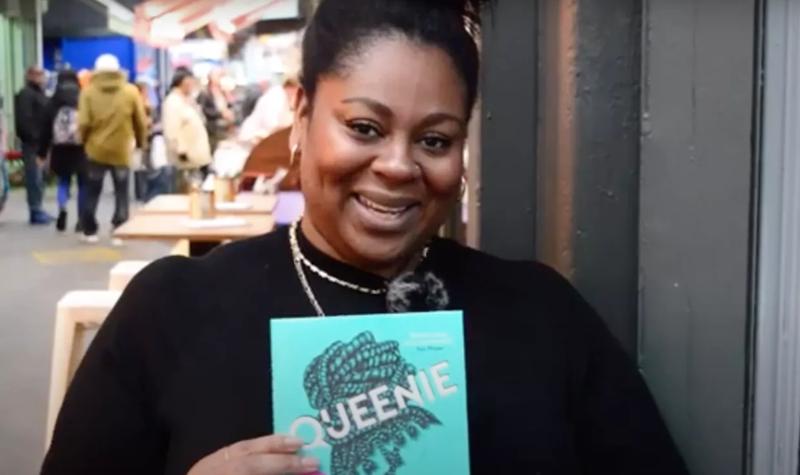 Candice Carty-Williams holds her book Queenie in Brixton Market