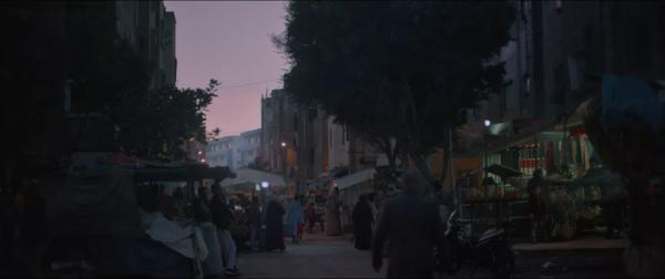 A Moroccan street market is lit by the setting sun. 