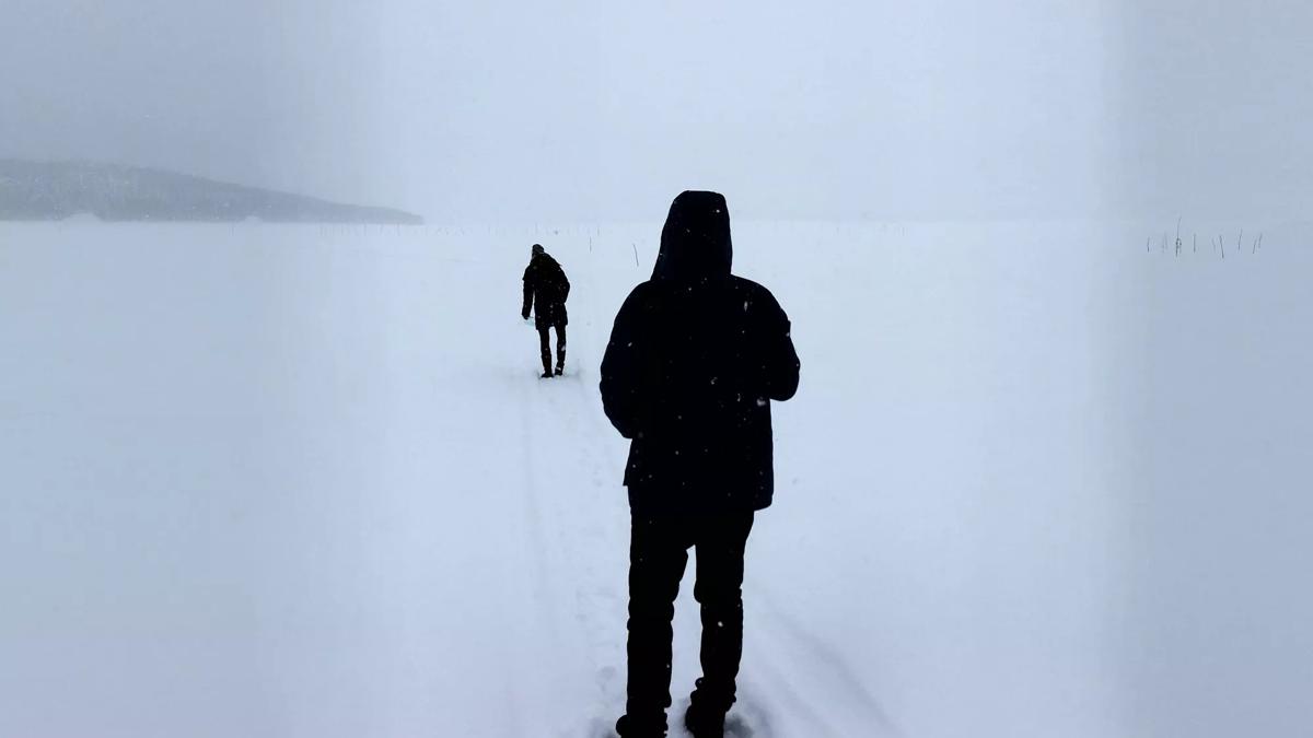 Two people walking in snow