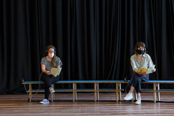 Two women seated listening to an audio made by Art by Post Participants. Installation view: Art by Post: Of Home and Hope, Southbank Centre, 2021