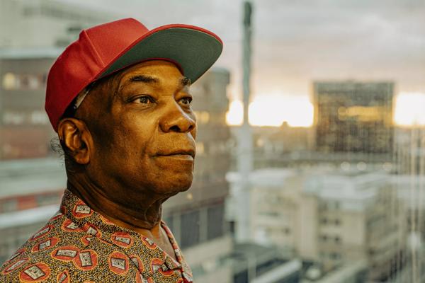 Musician Dennis Bovell sporting a red hat