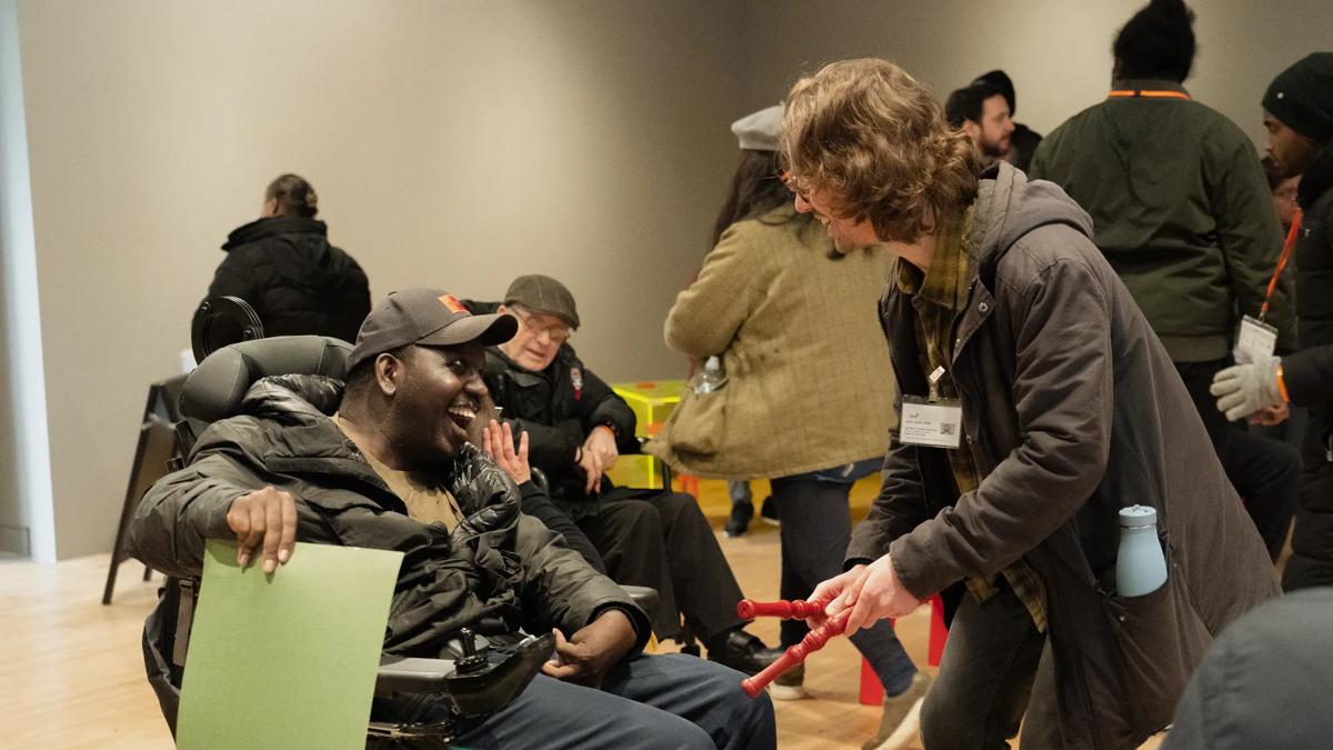 Participants visiting Hiroshi Sugimoto exhibition in mobility chairs and stood smiling