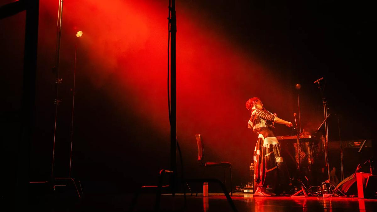 Rakhi from Manchester Collective in a red light playing violin