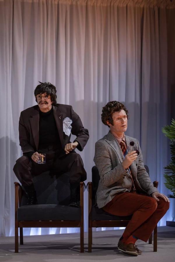 Adrienne Truscott as a playwright crouching on a chair and Feidlim Cannon as an interviewer sitting on a chair