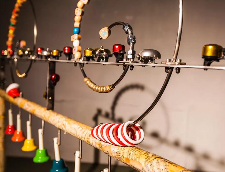 A structure with bicycle bells, hand bells and movable wooden beads