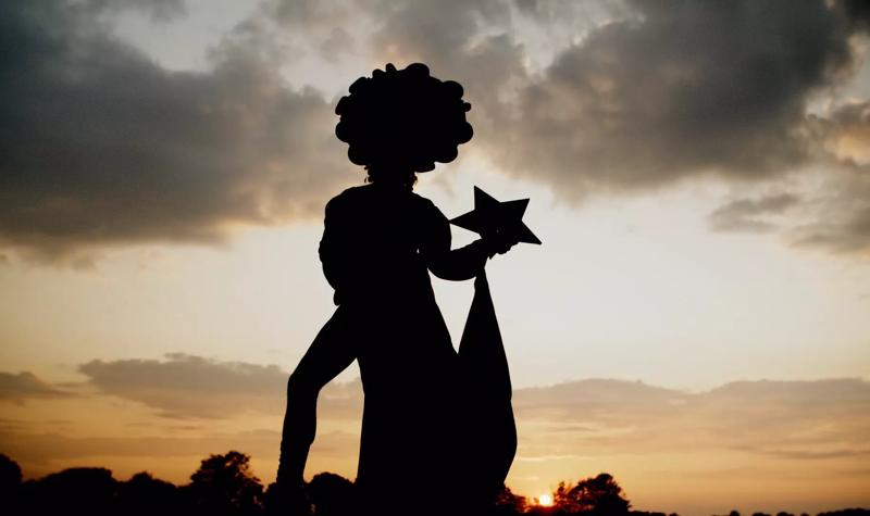 Silhouette of a drag queen under a sunset