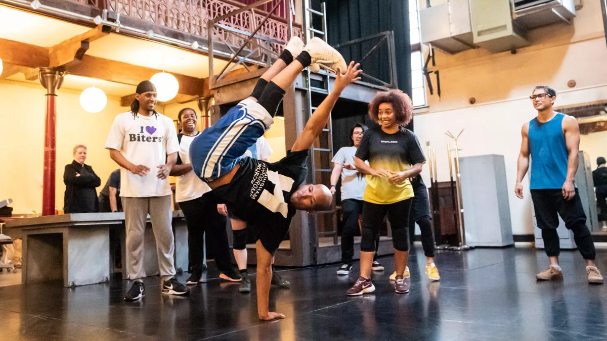 A group of breakdancers watching a man do a handstand