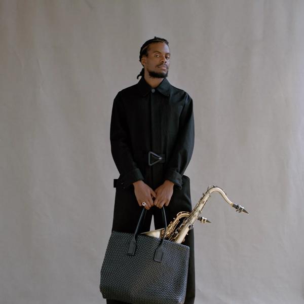DJ cktrl  holding a large handbag with saxophone 