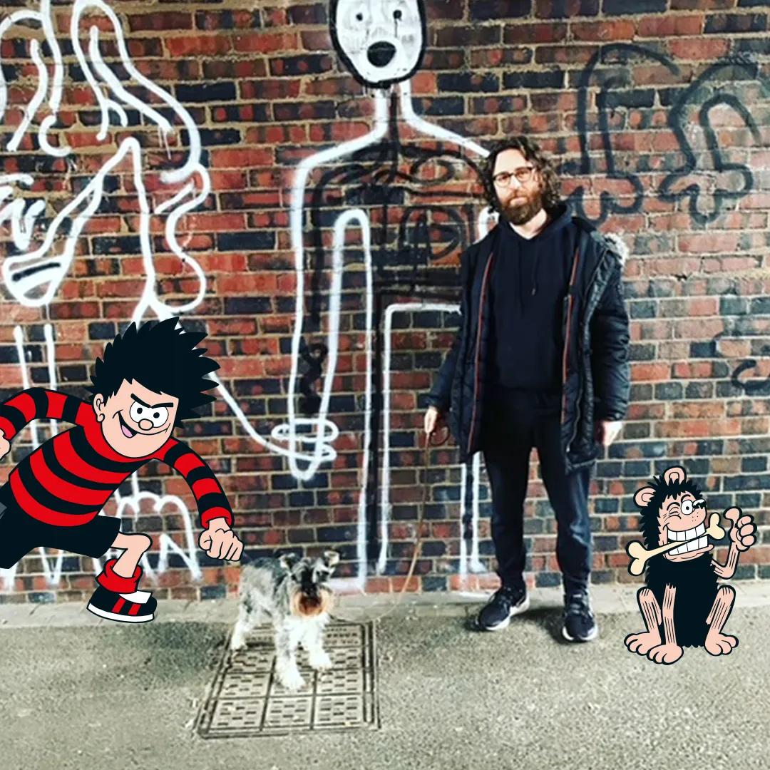 Composer Gavin Higgins and his dog, flanked by illustrations of Dennis and Gnasher