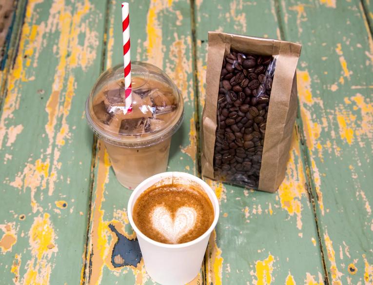 Photo showing a caffe latte, an iced coffee and a bag of coffee beans,  sold by For The Good of the People at Southbank Centre Food Market