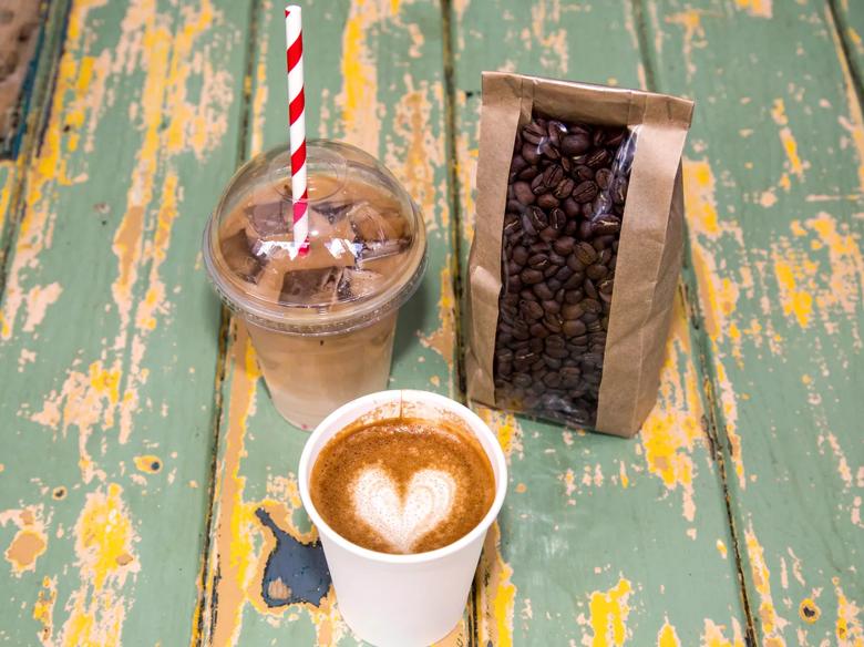 Photo showing a caffe latte, an iced coffee and a bag of coffee beans,  sold by For The Good of the People at Southbank Centre Food Market