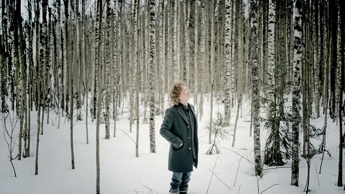 Santtu-Matias Rouvali standing in front of a lake and forest in Finland